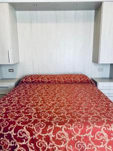 リミニにあるHotel Belmarのベッドルーム1室(赤いベッドカバー付きの大型ベッド1台付)