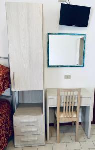 a bedroom with a desk and a chair and a mirror at Hotel Belmar in Rimini