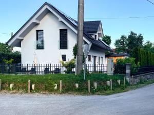 una casa blanca con techo negro en Rooms Minka en Kamna Gorica