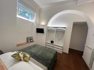 1 dormitorio con cama y ventana abovedada en Eccelso Suites, en Roma