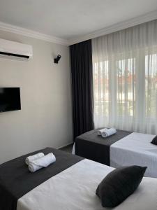um quarto de hotel com duas camas e uma janela em Moni Homes em Fethiye