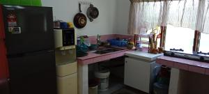 a kitchen with a black refrigerator and a sink at MYHome@Langkawi in Pantai Cenang