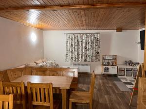 a dining room with a table and a kitchen at Chalupa U Smrku in Horní Polubný