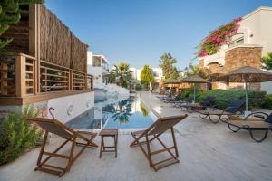 a patio with chairs and a swimming pool at Costa Sariyaz Hotel Bodrum in Bodrum City