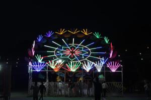 a large ferris wheel with colorful lights at night at Yes Boss By Backpackers Heaven Near New Delhi Train Station in New Delhi