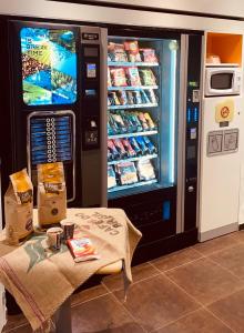 a vending machine with food and a table in front of it at ibis budget Noyon in Noyon