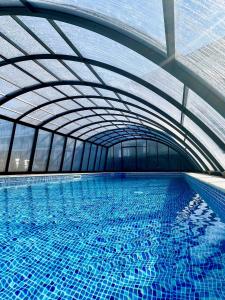a large swimming pool with a large ceiling at Apartament z basenem Baltic Garden Sztutowo, Mierzeja Wiślana in Sztutowo