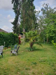 three park benches sitting in the grass in a yard at la Villa Mancelle in Le Mans
