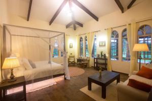 1 dormitorio con cama, sofá y mesa en Chara Africa Hotel, en Usa River