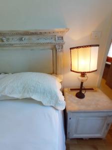 a lamp on a night stand next to a bed at Hotel Oviv dimora del borgo in Acquaviva Picena