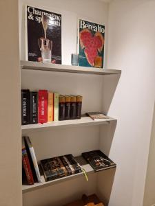 a book shelf filled with books next to a wall at Dario Coos srl - Azienda vinicola 