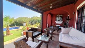 sala de estar con sofá y sillas en el patio en Villa Victoria con piscina en Tarifa