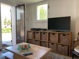 een woonkamer met een tv en een salontafel bij Tranquil apartment surrounded by nature & golf in Écharvine