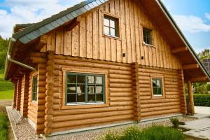 une cabane en rondins avec un toit en gambrel dans l'établissement Das Landchalet, à Steinwiesen