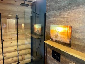 a bathroom with a glass shower with a picture of a deer at Das Landchalet in Steinwiesen