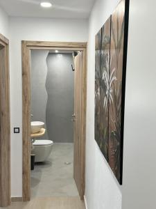 La salle de bains est pourvue de toilettes et d'une porte menant à une chambre. dans l'établissement CRETelia House, à Palaiokastro