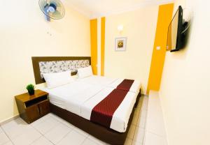 a bedroom with a bed and a tv on the wall at Sun Inns Dmind Seri Kembangan in Seri Kembangan
