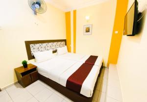a bedroom with a bed and a television in it at Sun Inns Dmind Seri Kembangan in Seri Kembangan