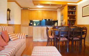 ein Wohnzimmer mit einem Tisch und einer Küche in der Unterkunft Charming 3 bedroom on Jack Nicklaus golf course - Estoril in Crans-Montana