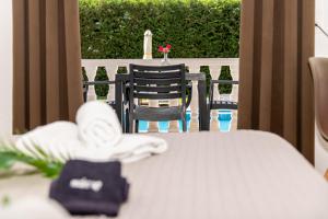 a table and chairs on a porch with a flower on it at Alterego Studios in Laganas