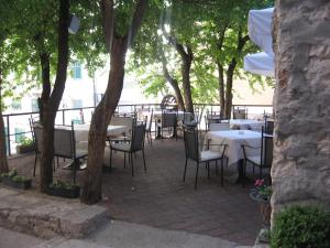 an outdoor patio with tables and chairs and trees at Pansion Sibenik in Šibenik