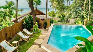 a backyard with a swimming pool and chairs at Kalulushi Bungalows in Haad Pleayleam