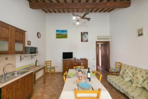 cocina y sala de estar con mesa y sofá en Il Pino - appartamento Tiglio, en Cecina