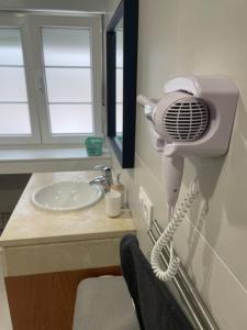 a bathroom with a hair dryer on the wall next to a sink at APARTAMENTO CASCO HISTORICO DE PRAVIA - HENO PRAVIA in Pravia