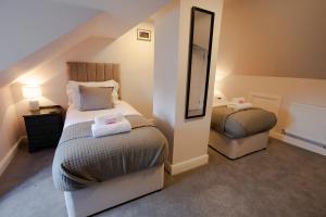 Habitación pequeña con 2 camas y espejo. en Woodfalls Inn, en Redlynch