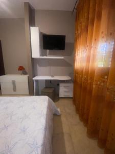 a bedroom with a bed and a desk and a television at VILLA HELENA in Lampedusa