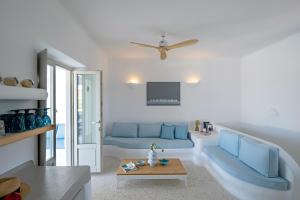 sala de estar con sofá azul y mesa en Angels Villas - Prime Concept, en Naousa