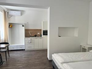 a white room with a bed and a kitchen at Apartment Zhang in Graz