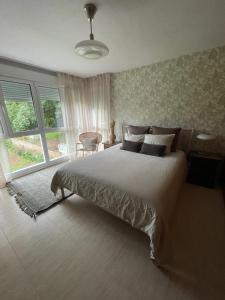 Un dormitorio con una cama grande y una ventana en KASABOBA, en Parres de Llanes