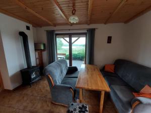 a living room with a couch and a table at Domki nad jeziorem - Posiadłość Nad Zatoką in Ryn