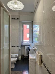 a bathroom with a sink and a toilet and a window at Casa Vittoria a due passi da Milano (near Milan) in Cesano Boscone