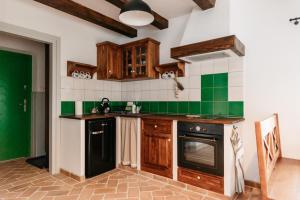 eine Küche mit grünen und weißen Wandfliesen in der Unterkunft Osada Biały Wilk domek "Zielony" in Przysłup