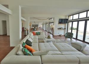 uma ampla sala de estar branca com um grande sofá branco em Grande Villa 750 m2 Le Mas des chênes em Bormes-les-Mimosas