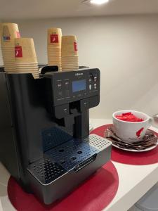 a black coffee maker with a bowl of red fruit at La Cattedrale in Reggio di Calabria