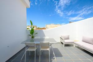 patio ze stołem i krzesłami na białej ścianie w obiekcie LOFT2STAY.COM w Maladze