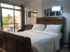 una camera con un grande letto e un balcone di Gmb-Arte' Hotel a Sogod