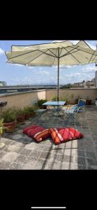 a table and chairs and an umbrella on a patio at Appartamento con ampio Terrazzo in Rome