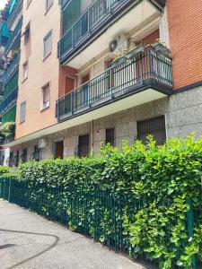 eine Hecke vor einem Gebäude mit Balkon in der Unterkunft Casa Vittoria a due passi da Milano (near Milan) in Cesano Boscone