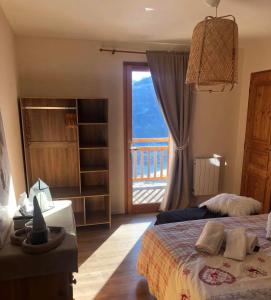 a bedroom with a bed and a large window at Chalet Mariabel in Puy-Saint-Pierre