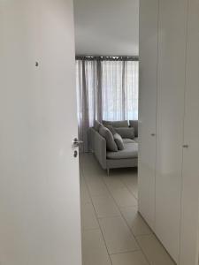 Dolcevita Locarno في لوكارنو: غرفة معيشة بيضاء مع أريكة ونافذة