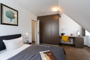 um quarto com uma cama e uma secretária com uma cadeira amarela em Hotel Parkresidenz Christian VIII em Archsum