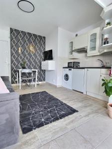een keuken met witte kasten en een zwart tapijt bij Le Petit Pradignac Croisette - Connect Property in Cannes