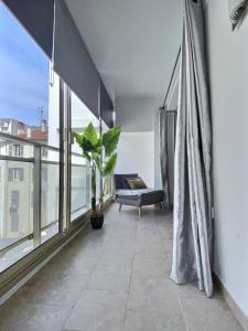 een balkon met een bank en een groot raam bij Le Petit Pradignac Croisette - Connect Property in Cannes