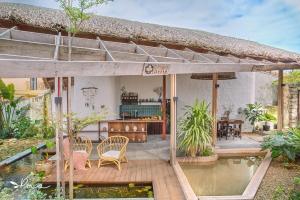 a house with a patio with a pond in front of it at Pao Homes - An Bang Beach Stone Villa in An Bang