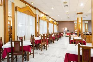 un comedor con mesas y sillas con mantel rojo en Hotel Zeus, en Mérida