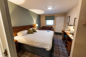 a bedroom with a bed and a desk in a room at The Lindisfarne Inn - The Inn Collection Group in Beal